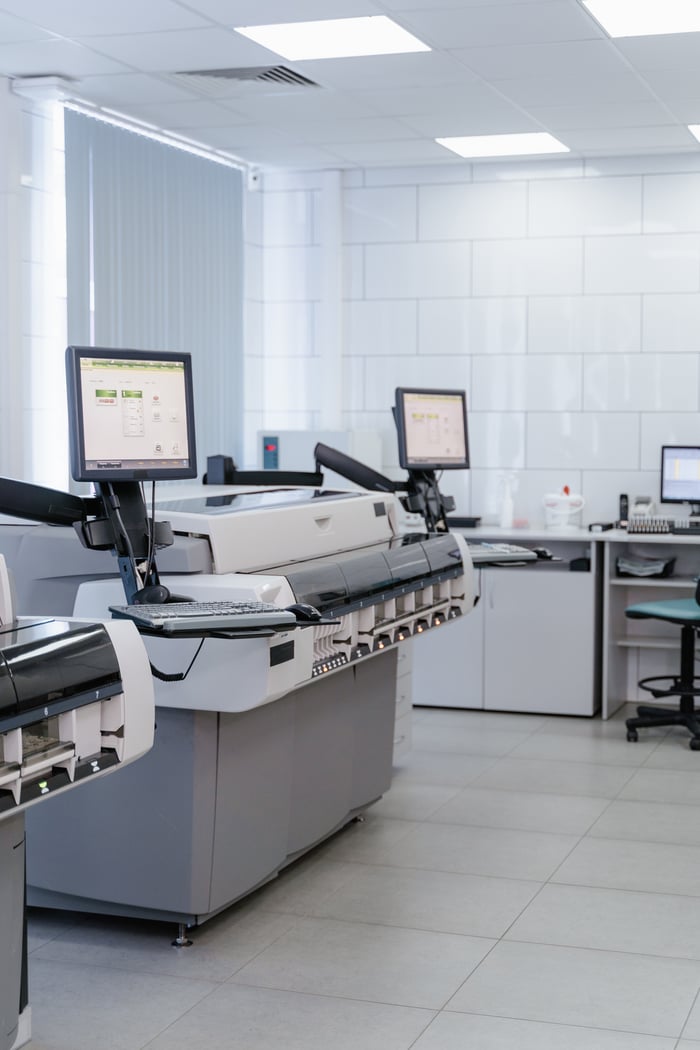 Bright and organized laboratory featuring high-tech printers and workstations.
